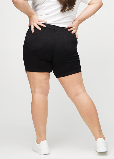 Sorte skinny short shorts set bagfra på en plus-size model, så man kan se hele produktet.