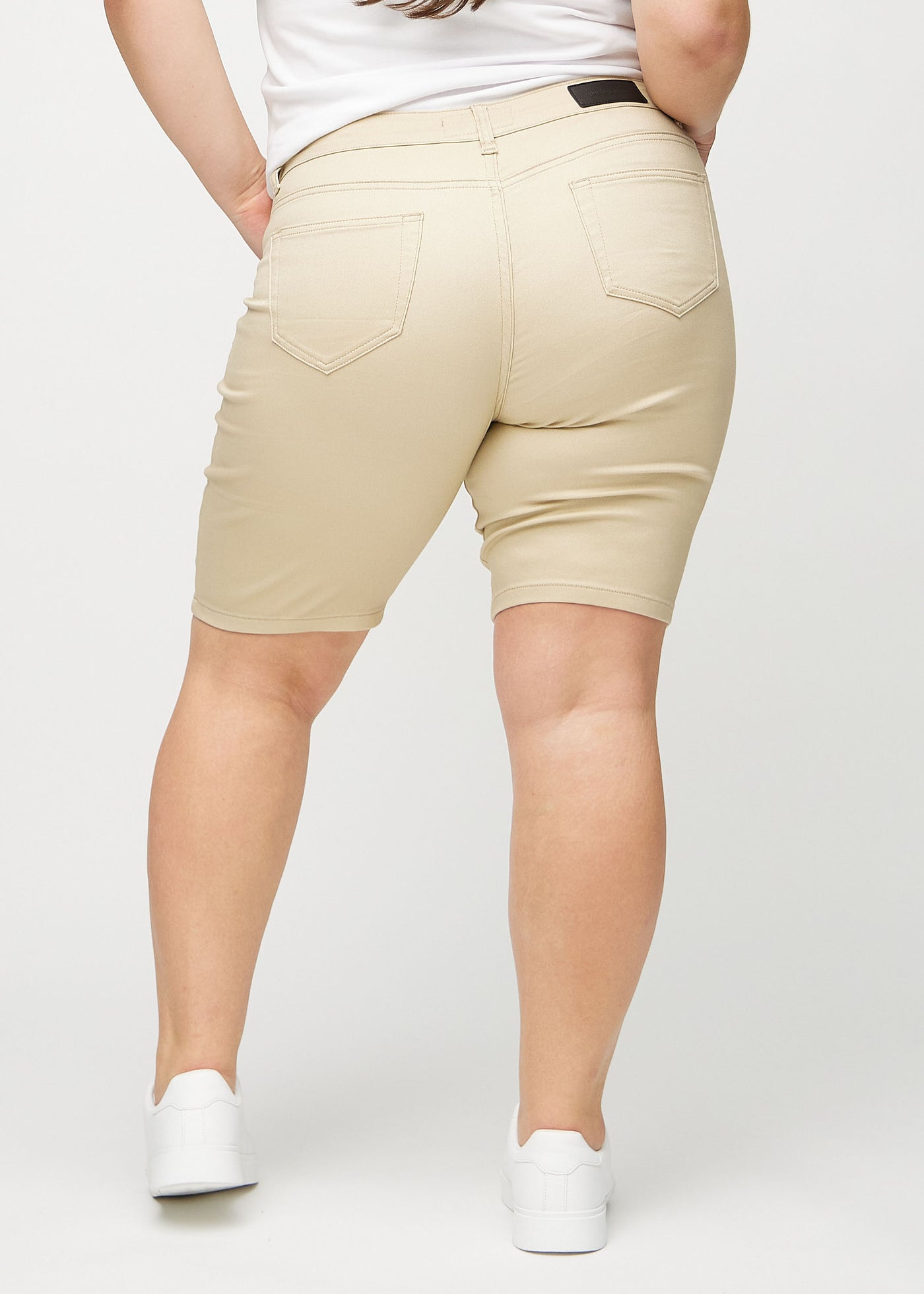 Beige skinny middle shorts set bagfra på en plus-size model, så man kan se hele produktet.