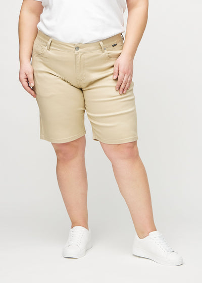 Beige regular middle ultra high rise shorts, modelnavn Gazelles, som går lige ned langs benet og sidder højt i taljen på en plus-size model, set forfra.