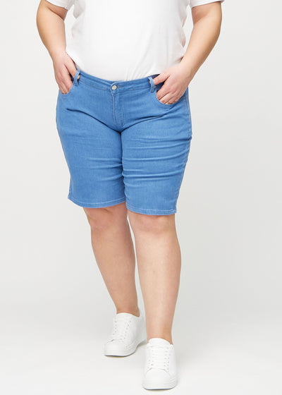 Blå regular middle shorts, modelnavn Geraniums, som går lige ned langs benet og slutter lige over knæet på en plus-size model, set forfra.