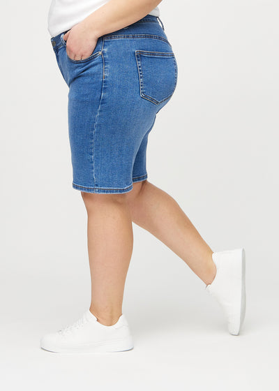 Denim regular middle ultra high rise shorts set fra siden på en plus-size model.