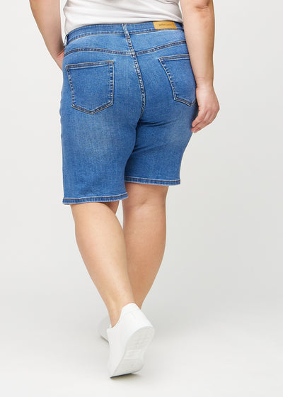 Denim regular middle ultra high rise shorts set bagfra på en plus-size model, så man kan se hele produktet.