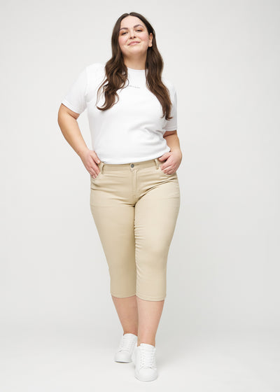 Fuldt billede af en plus-size model i beige skinny capris.