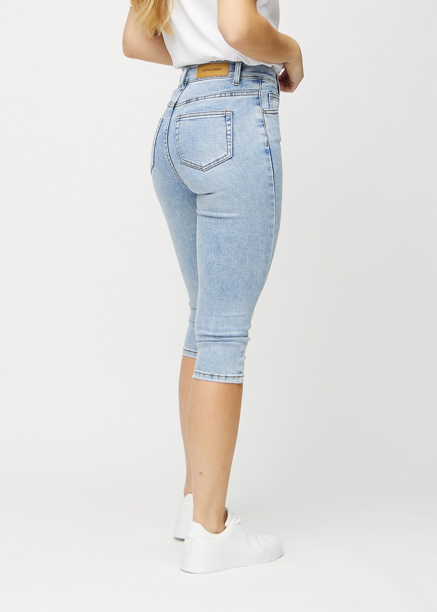 Lys denim skinny capris set bagfra, så man kan se hele produktet.