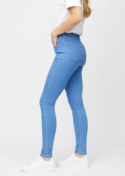 Blå skinny jeans set fra siden på model.