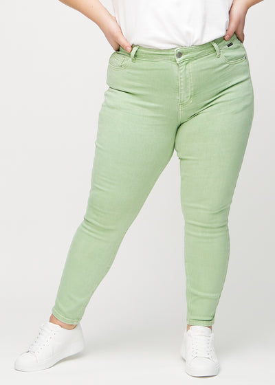 Lysegrønne skinny jeans, modelnavn Mints, som sidder tæt til benet på en plus-size model, set forfra.