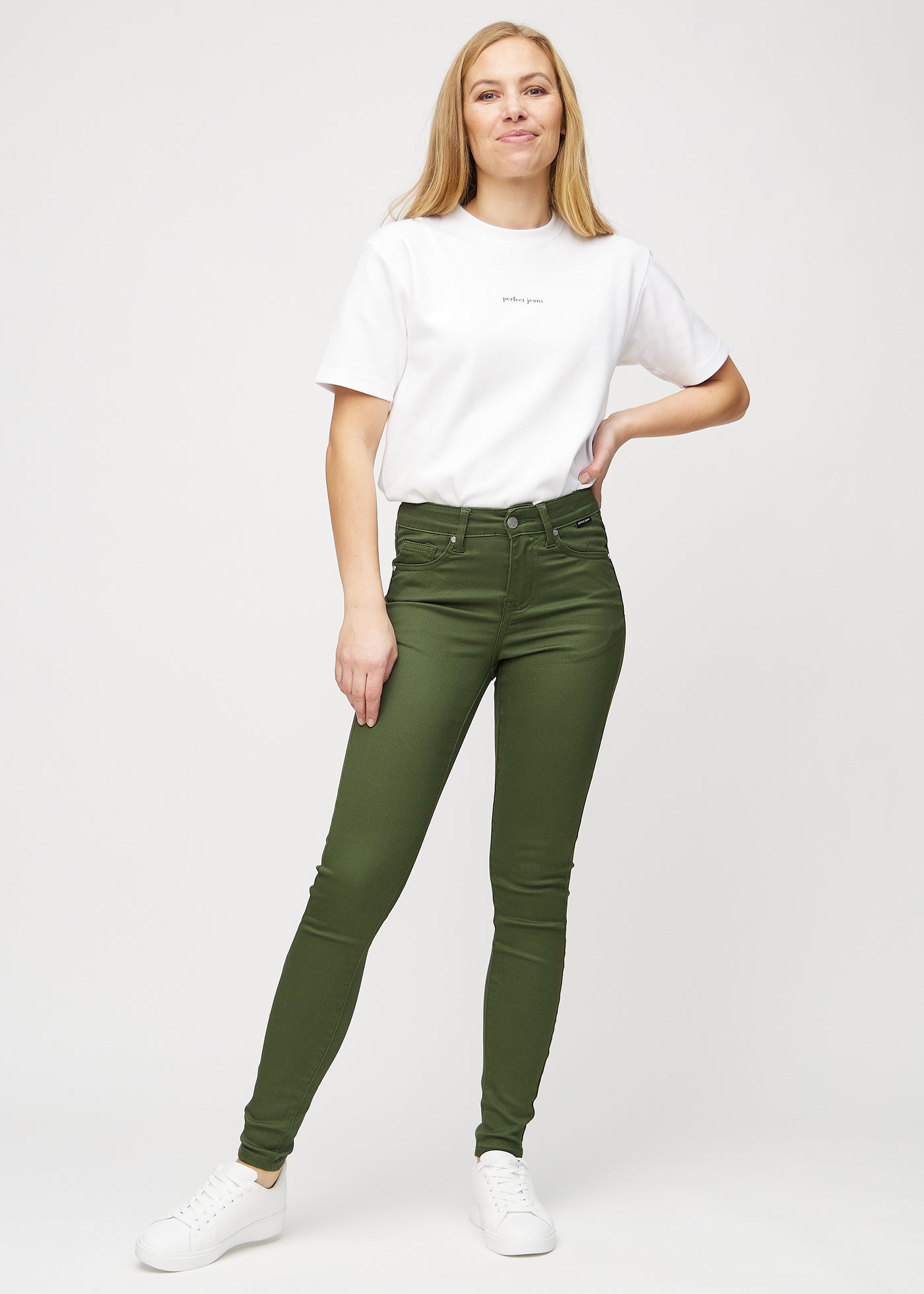 Fuldt billede af model i mørkegrønne skinny jeans.