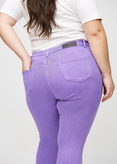 Lilla skinny jeans set bagfra tæt på en plus-size model for at vise detaljer.