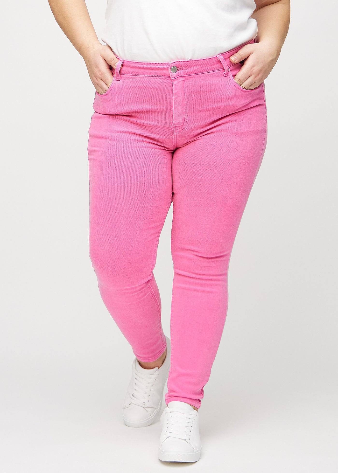 Lyserøde skinny jeans, modelnavn Flamingos, som sidder tæt til benet på en plus-size model, set forfra.