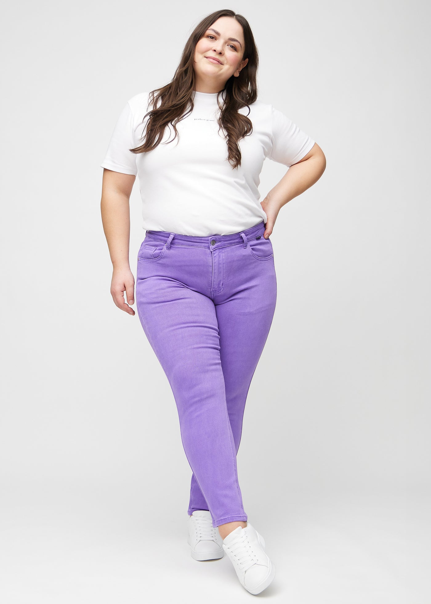 Fuldt billede af en plus-size model i lilla slim jeans.