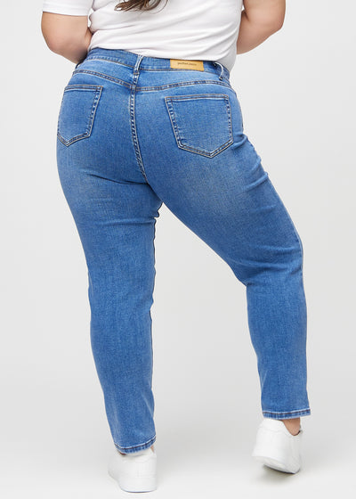 Denim slim jeans set bagfra på en plus-size model, så man kan se hele produktet.