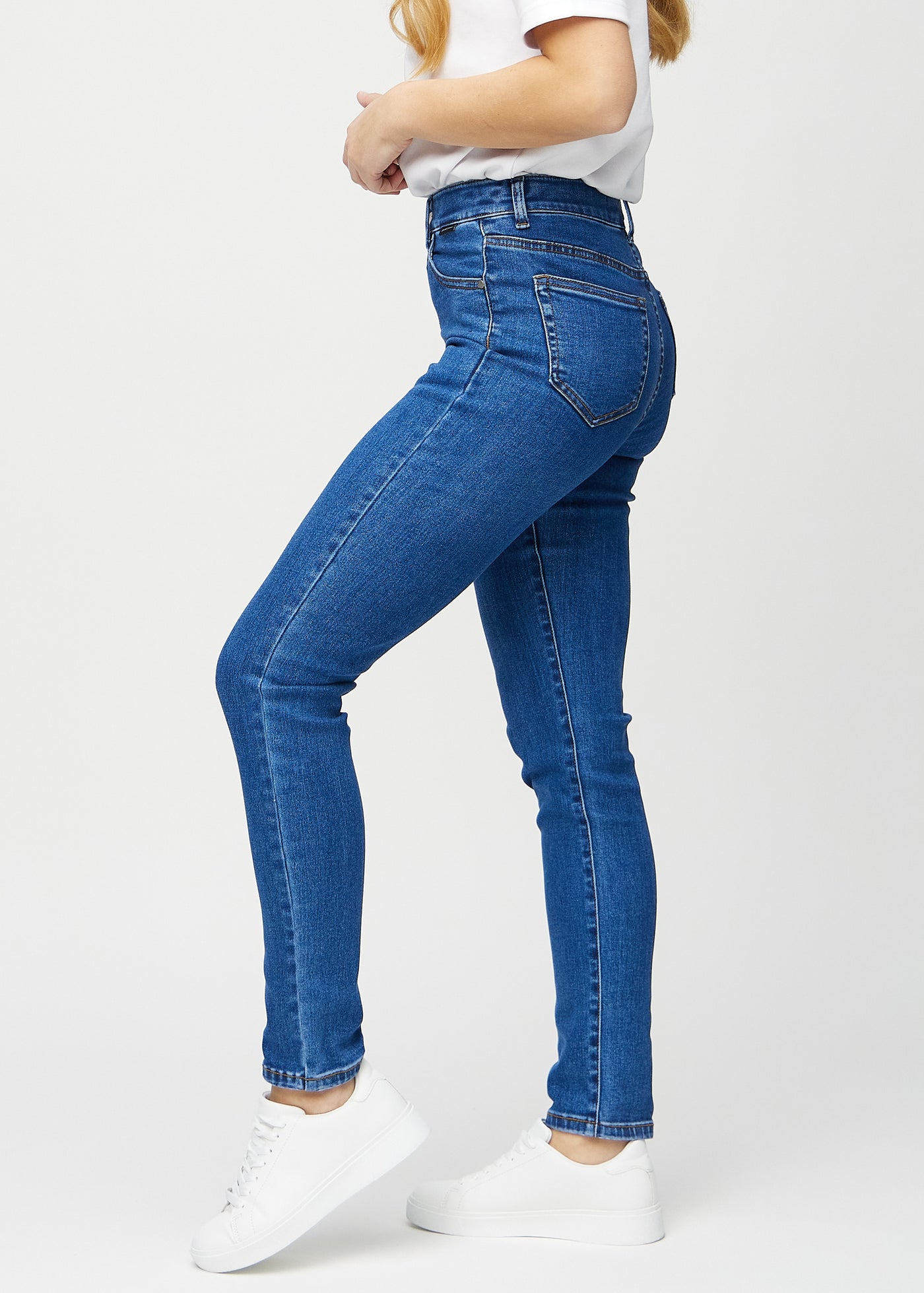 Mørk denim slim jeans set fra siden på model.