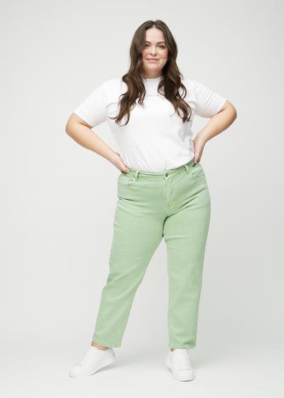 Fuldt billede af en plus-size model i lysegrønne regular jeans.