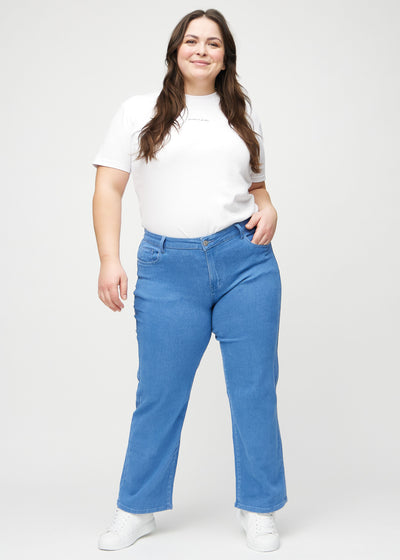 Fuldt billede af en plus-size model i blå loose jeans.