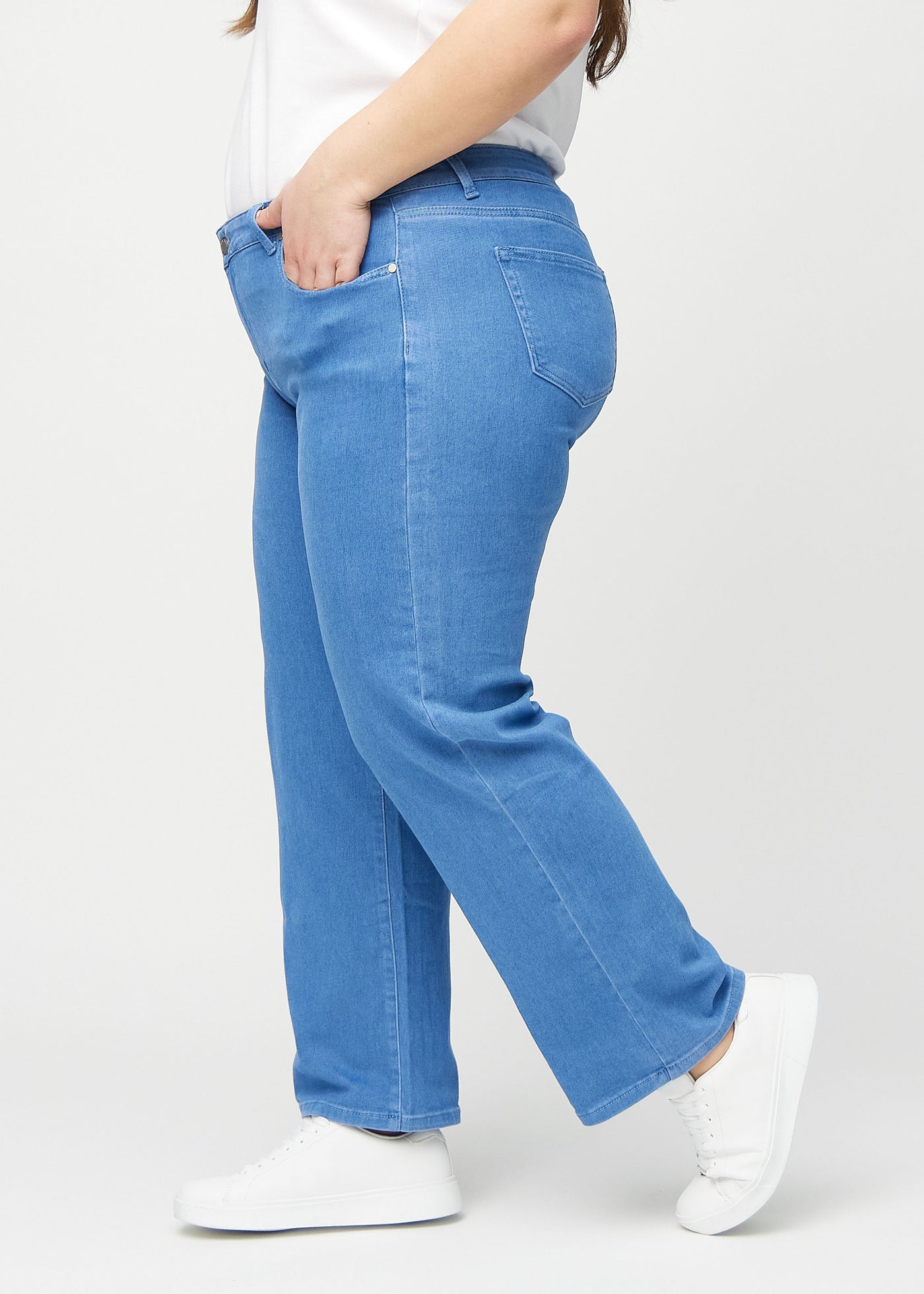 Blå loose jeans set fra siden på en plus-size model.