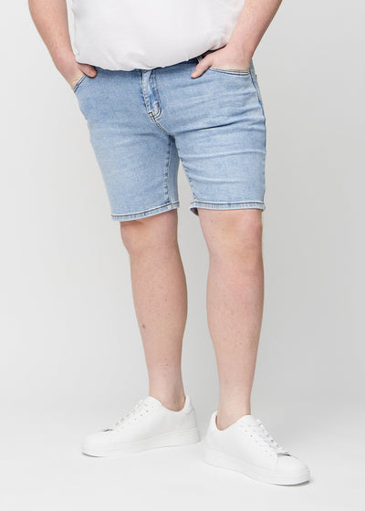 Lys denim regular middle shorts, som sidder lige langs låret og slutter lige over knæet på en plus-size model, set forfra.