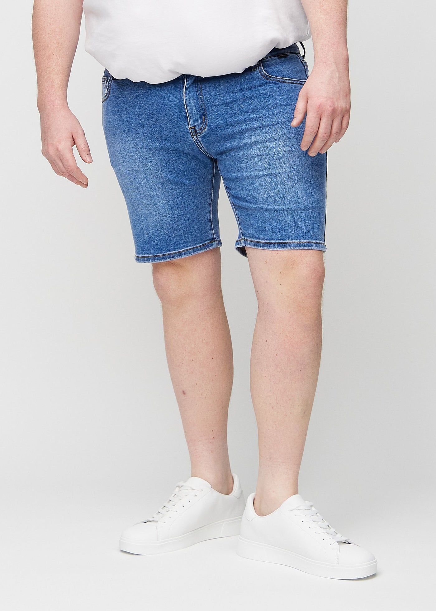 Denim regular middle shorts, som sidder lige langs låret og slutter lige over knæet på en plus-size model, set forfra.