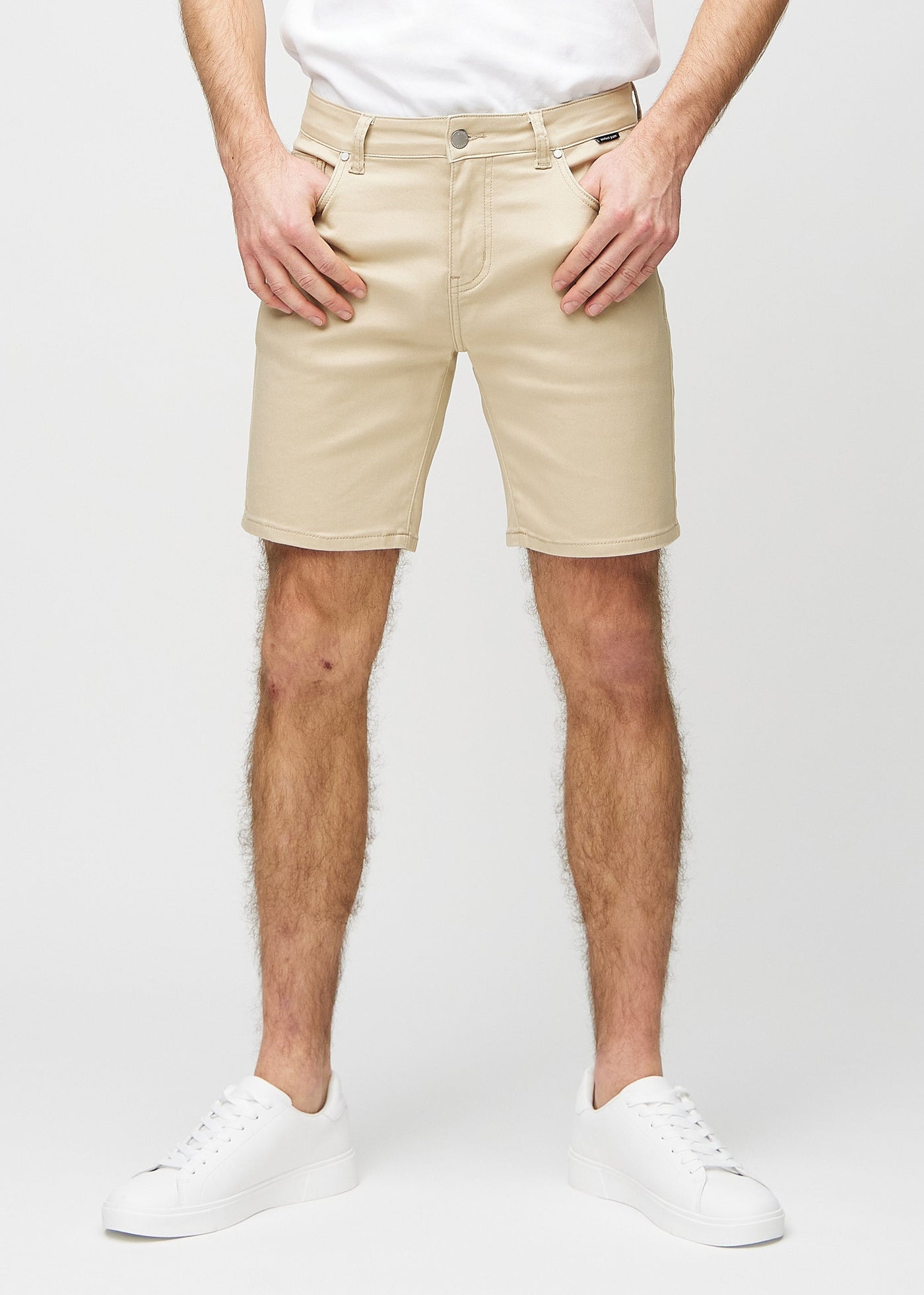 Beige regular middle shorts, som sidder lige langs låret og slutter lige over knæet, set forfra.