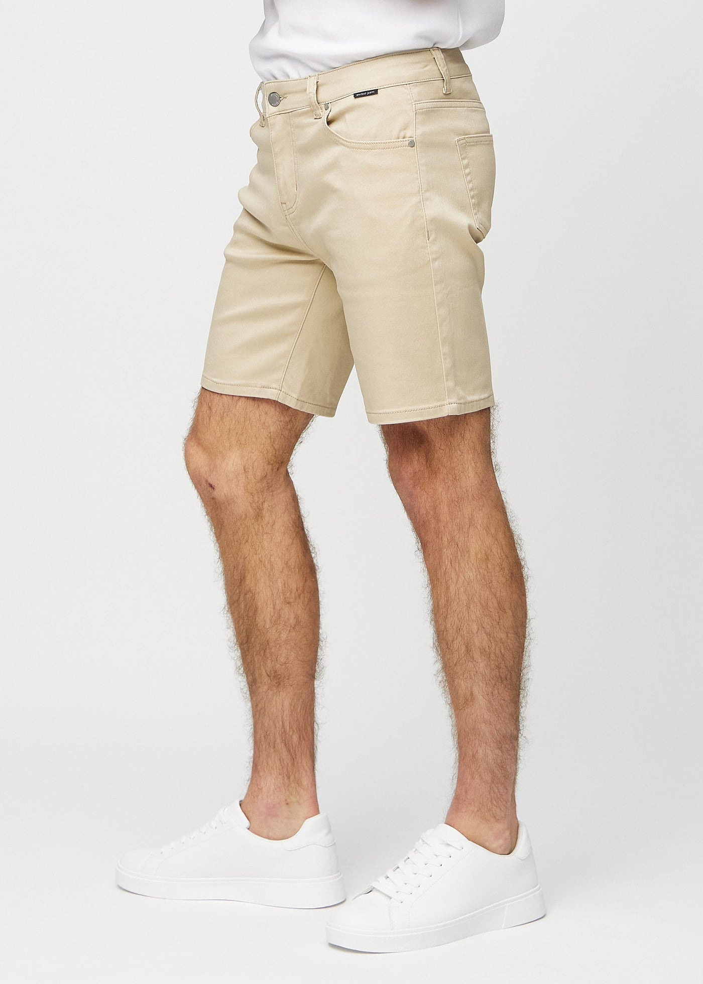 Beige regular middle shorts set fra siden på model.