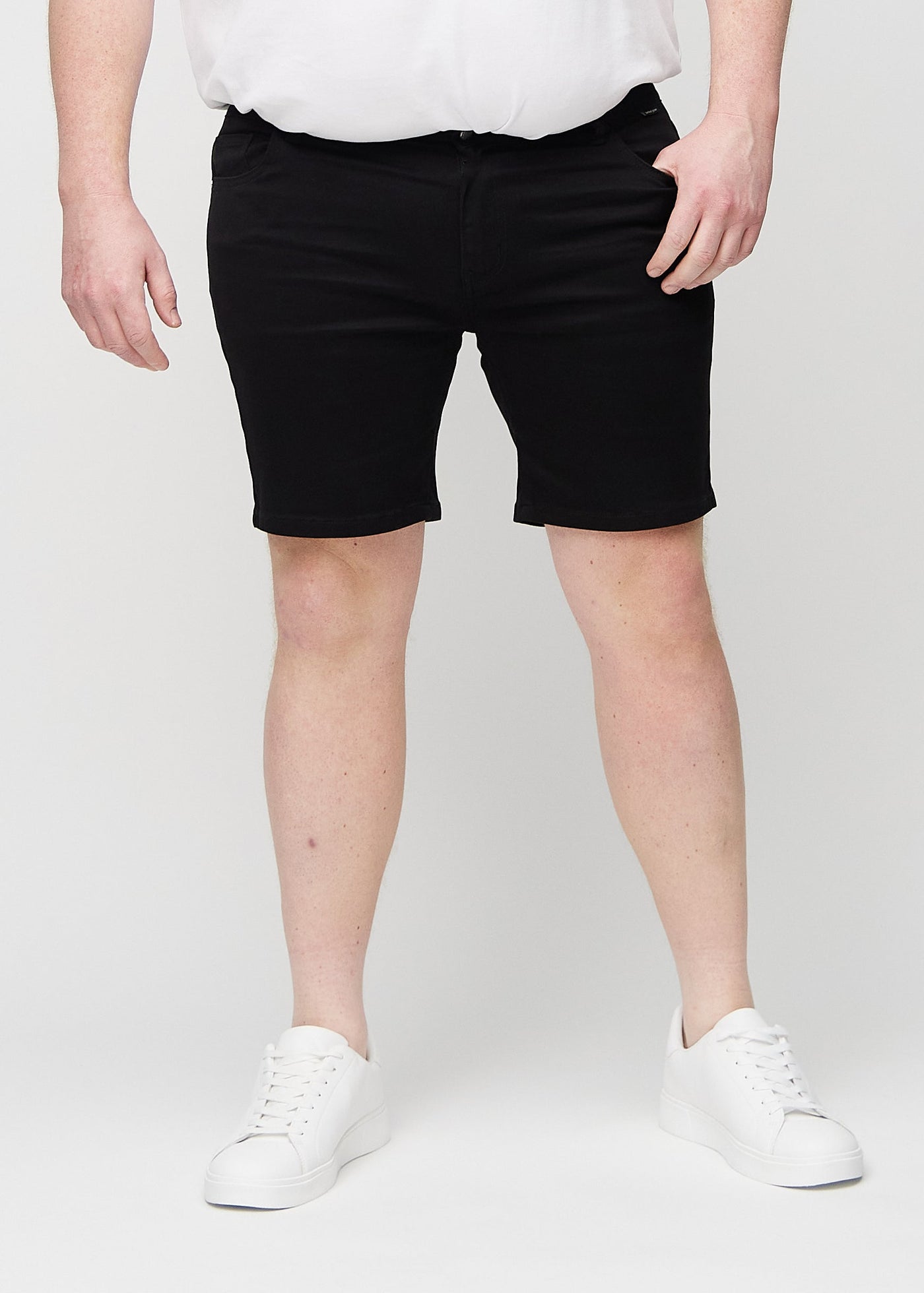 Sorte regular middle shorts, som sidder lige langs låret og slutter lige over knæet på en plus-size model, set forfra.