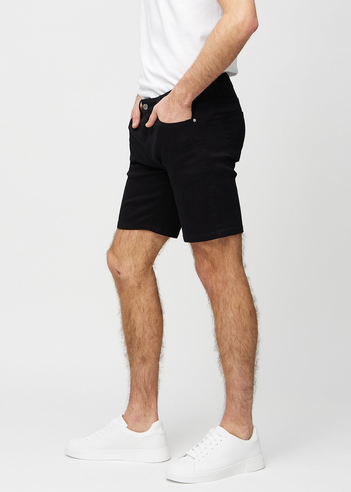 Sorte regular middle shorts set fra siden på model.