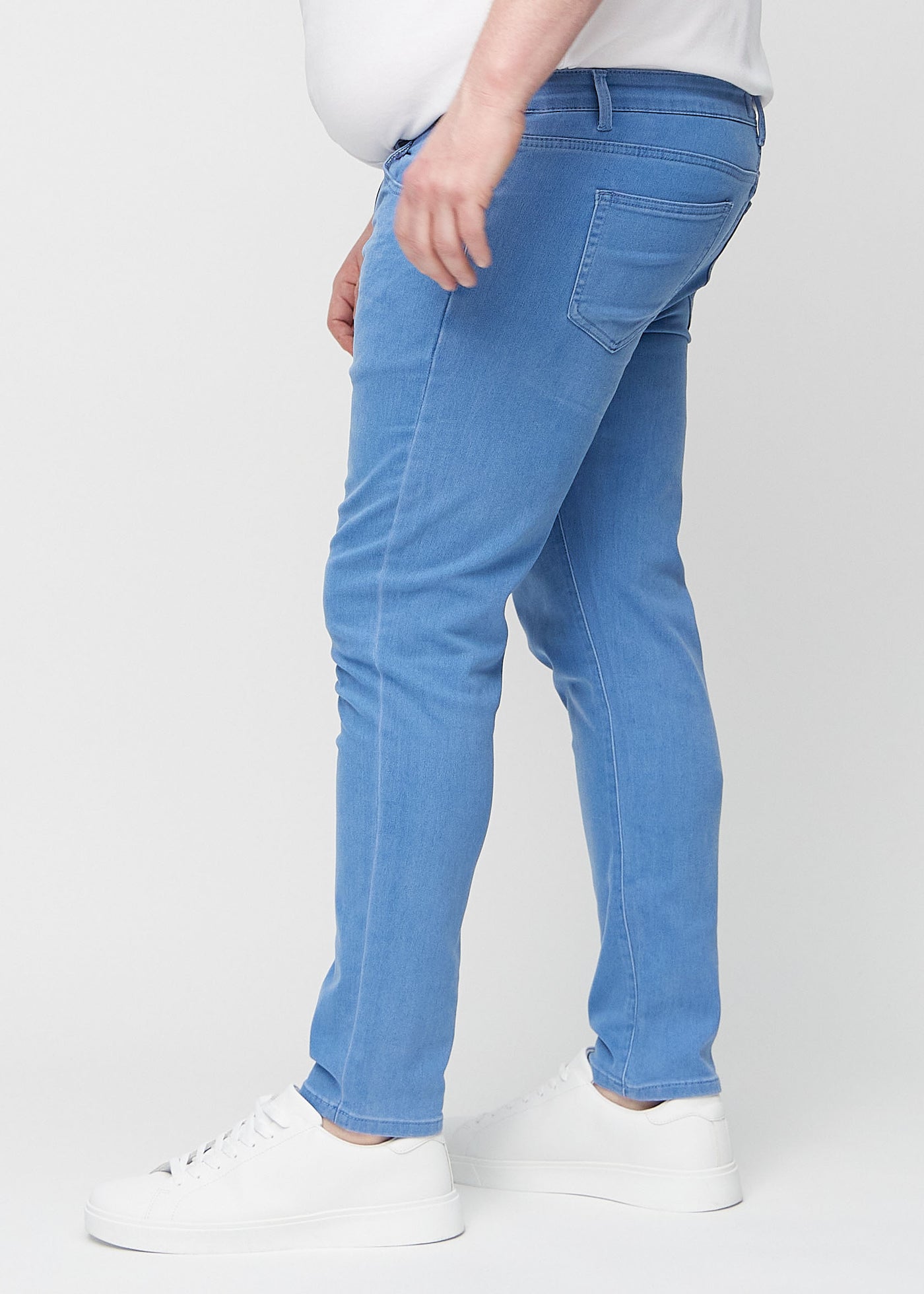 Blå slim jeans set fra siden på en plus-size model.