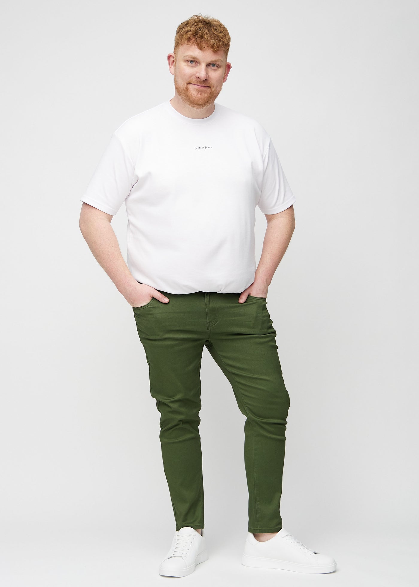 Fuldt billede af en plus-size model i mørkegrønne slim jeans.