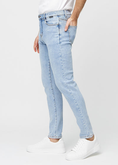 Lys denim slim jeans set fra siden på model.