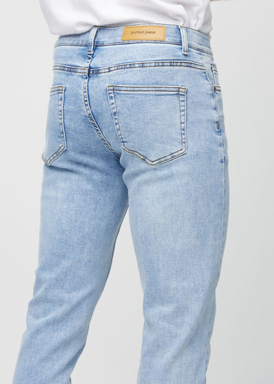 Lys denim slim jeans set bagfra tæt på for at vise detaljer.