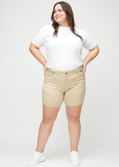 Plus-size model går ind i billedet, strækker i sine shorts, viser dem frem ved at dreje rundt, og forlader derefter billedet.