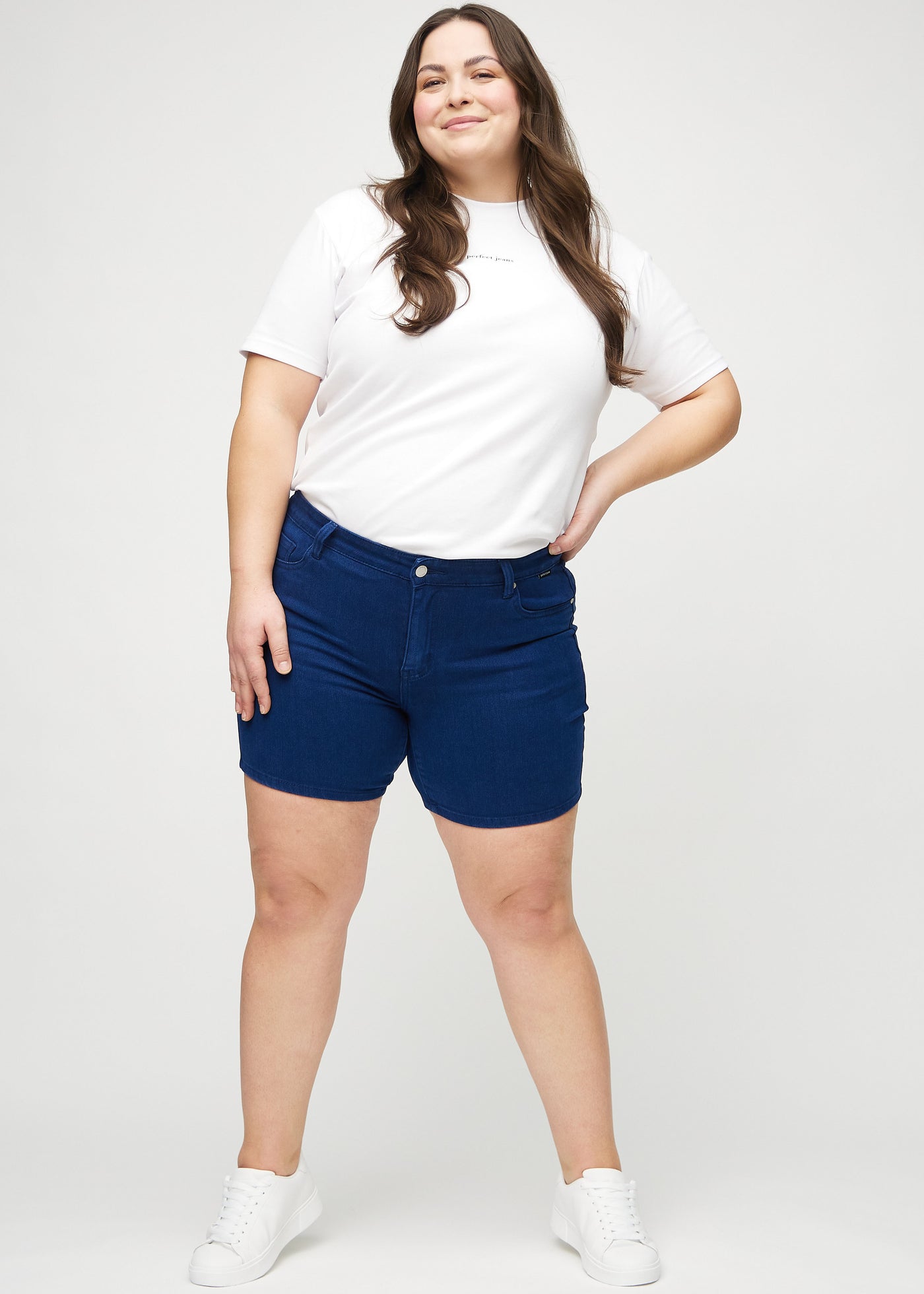 Plus-size model går ind i billedet, strækker i sine shorts, viser dem frem ved at dreje rundt, og forlader derefter billedet.