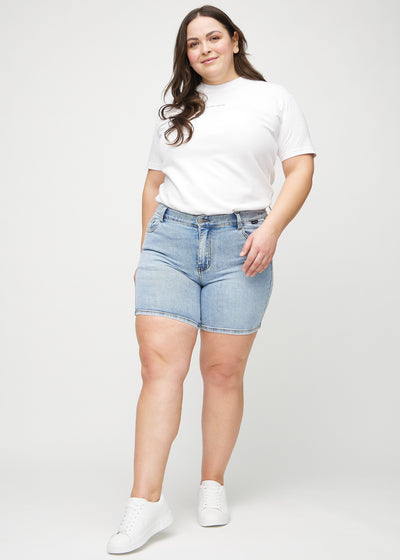 Plus-size model går ind i billedet, strækker i sine shorts, viser dem frem ved at dreje rundt, og forlader derefter billedet.