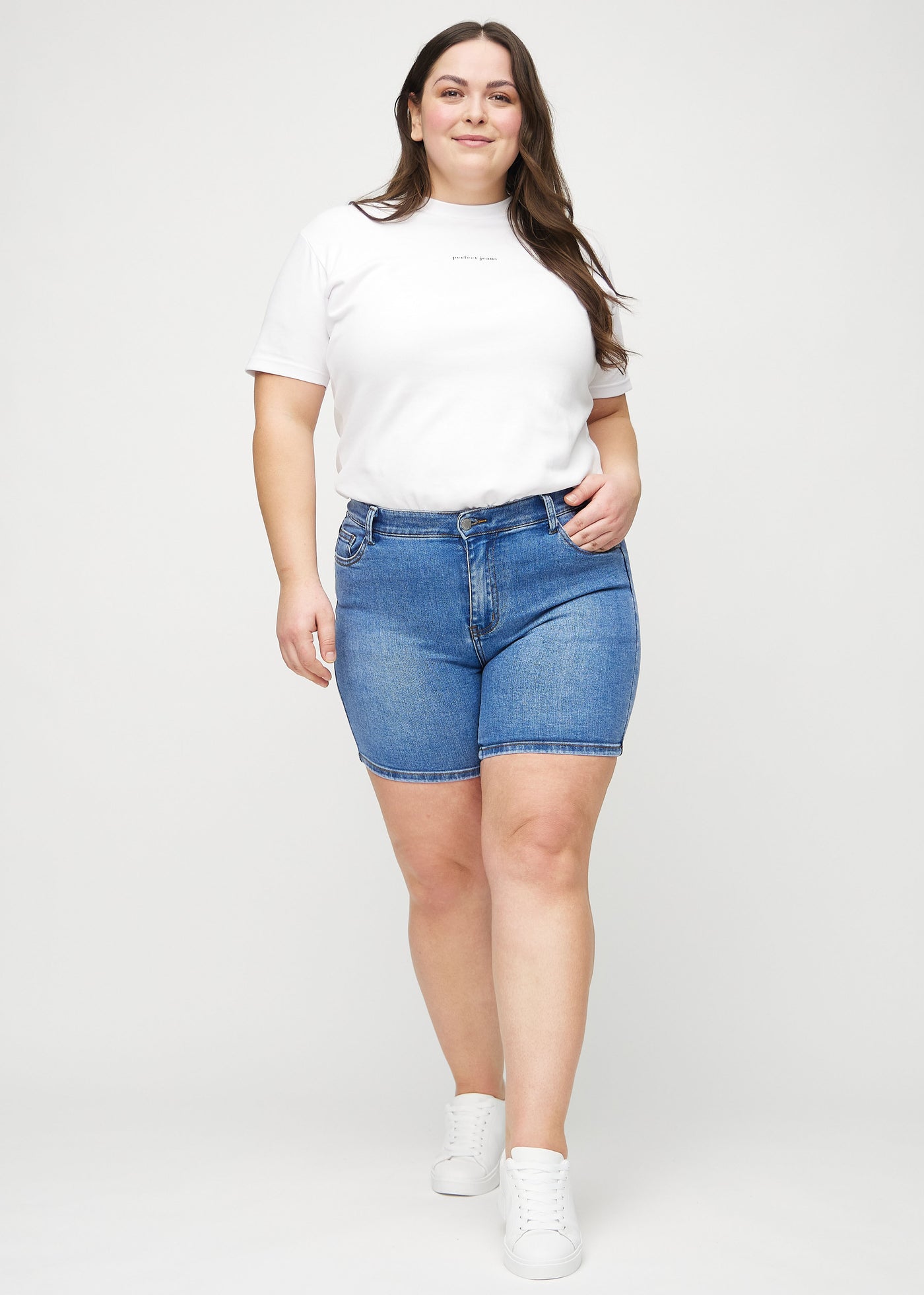 Plus-size model går ind i billedet, strækker i sine shorts, viser dem frem ved at dreje rundt, og forlader derefter billedet.